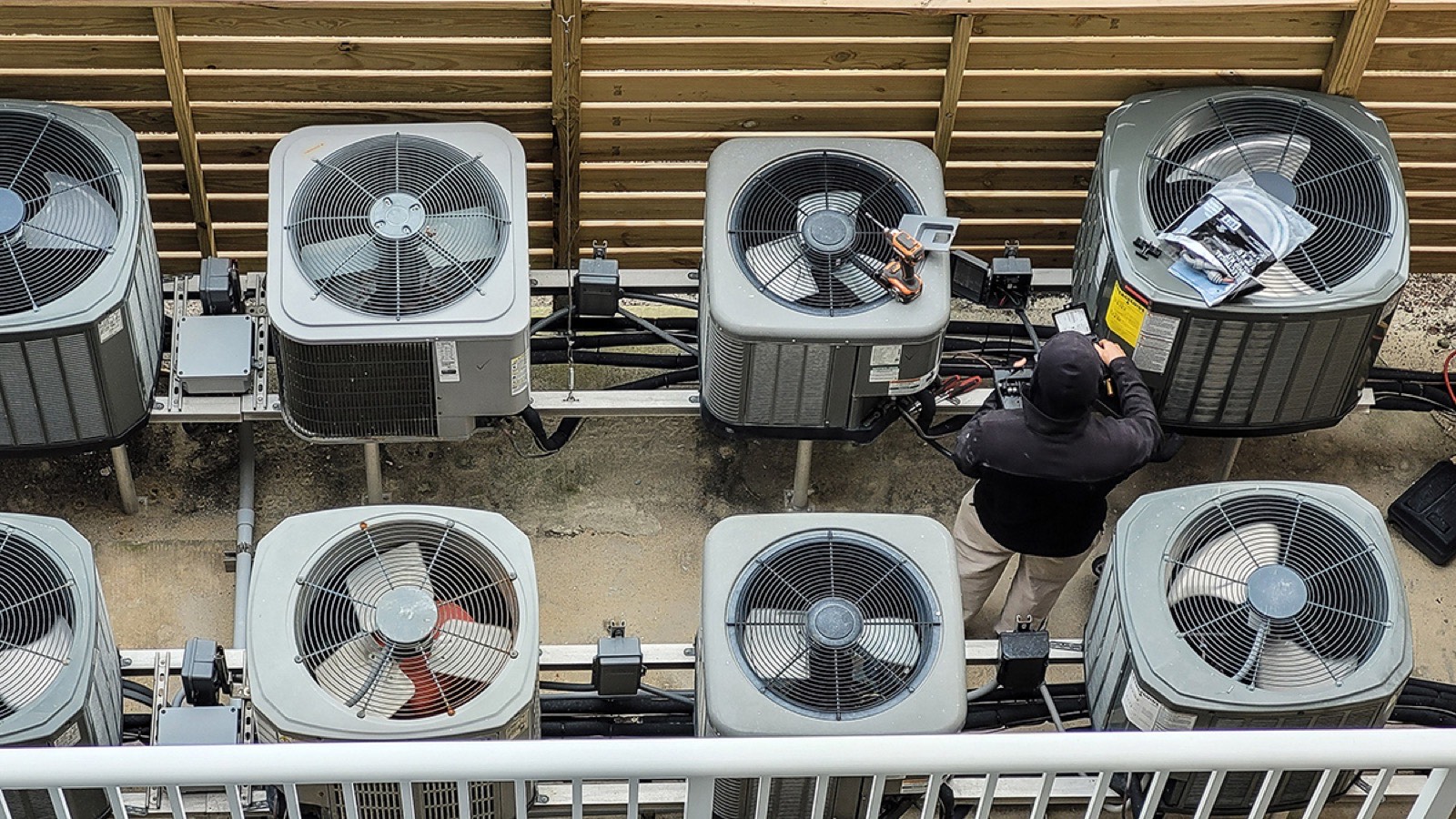 Technician servicing outdoor AC units