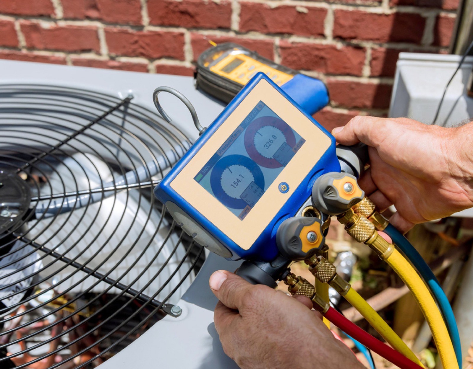 Technician using diagnostic gauges on an HVAC unit during a consultation